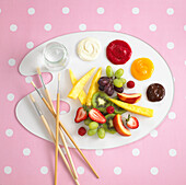 Fruit and sweet dips arranged on an artist's palette