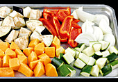 Spreading out the chopped vegetables on a roasting tray