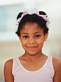 Smiling young girl wearing pink leotard