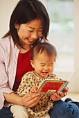 Woman reading book to a baby