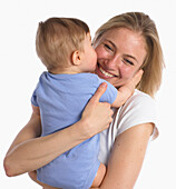 Baby boy kissing mother's cheek