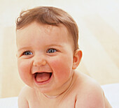 Laughing blue-eyed baby girl