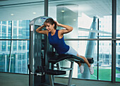 Woman lying on her front on a gym machine