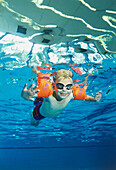 Boy wearing water wings in a swimming pool