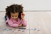 Girl lying on floor with jigsaw pieces in front of her