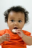 Baby girl eating cookie