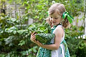 Girl holding cabbage in garden