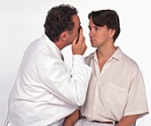 Doctor examining the cornea of a male patient