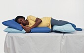 Pregnant woman lying on side supported by pillows