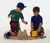 Two boys building a sandcastle