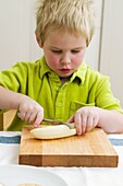 Boy slicing banana with knife