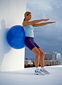 Woman leaning back against large exercise ball
