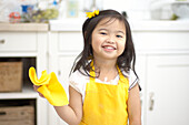 Girl holding yellow cloth and wearing yellow bow and apron