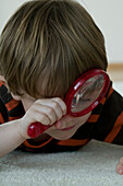 Boy looking through a magnifying glass