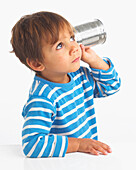 Boy holding tin can to his ear