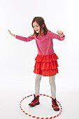 Girl in red skirt playing with hula-hoop