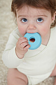 Baby girl chewing a teething ring