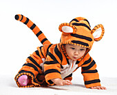 Baby girl wearing tiger suit crawling on floor