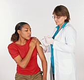 Doctor vaccinating young woman sitting on chair