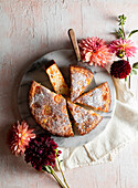 Sauerrahm-Kumquat-Kuchen dekoriert mit frischen Blumen