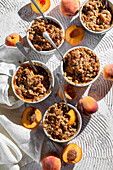 Summer peach crisp with oats in individual bowls