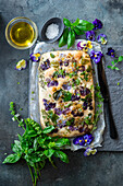 Focaccia with herbs and violet flowers