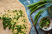 Prepare wild garlic bread: Put wild garlic pesto on the dough