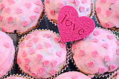 Muffins mit rosa Glasur und Zuckerherzen
