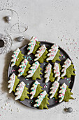 Matcha-Plätzchen mit weißer Schokoladenglasur und bunten Zuckerstreuseln in Tannenbaumform