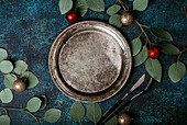 Rustic vintage metal empty plate and Christmas table decorated with eucalyptus branches
