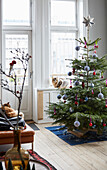 Decorated Christmas tree in front of a window with cat