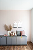 Cushion, purse, and vase with pampas grass on a grey sideboard