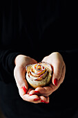 Hands holding an apple rose muffin