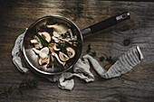 Raw oyster mushrooms with thyme, rosemary and basil in a pan