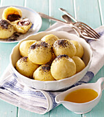 Plum dumplings made from choux pastry with poppy seeds
