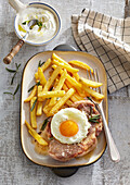 Pork steak with a fried egg and chips