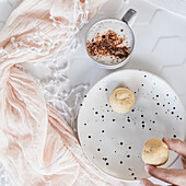 Childs hand holding shortbread cookies and a babychino in a stoneware espresso mug