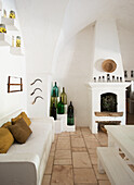 Mediterrane Küche mit Sitzbank, bunte Flaschen und gemauertem Kamin