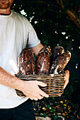 Man holding a basket with home-baked bread