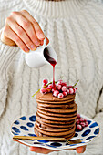 Chocolate pancakes with red currants, a woman is holding a saucer
