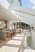 Küche mit Kücheninsel und Essbereich in offenem Raum mit Dachverglasung