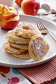 Apple rings in pancake batter with powdered sugar