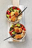 A quinoa bowl with glazed chicken, broccoli and peppers