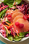 Pink beetroot bowl with spinach, grapefruit and raspberries (close-up)