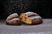 Stollen being dusted with icing sugar