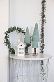 Decorative side table arrangement with miniature house and felt fir trees