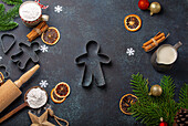 Weihnachtsbäckerei: Backutensilie, Mehl, Tannenzweig und Ausstechformen aus Metall
