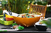 Bunte Schale mit Kartoffelsalat auf Gartentisch