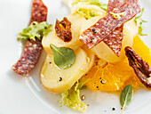 Potato salad with oranges, salami, and dried tomatoes