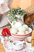 Fresh eggs in a bowl in front of a mortar and pestle